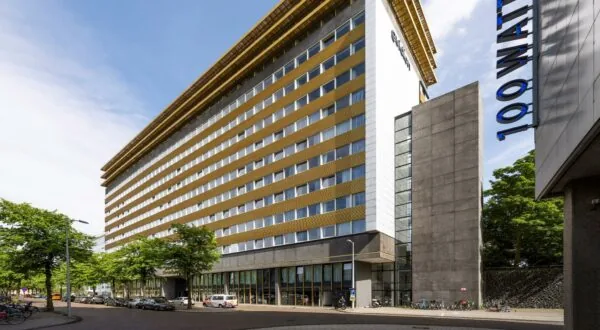 Modern kantoorgebouw aan de James Wattstraat met gouden gevelaccenten en de naam "100WATT" op de voorgrond.